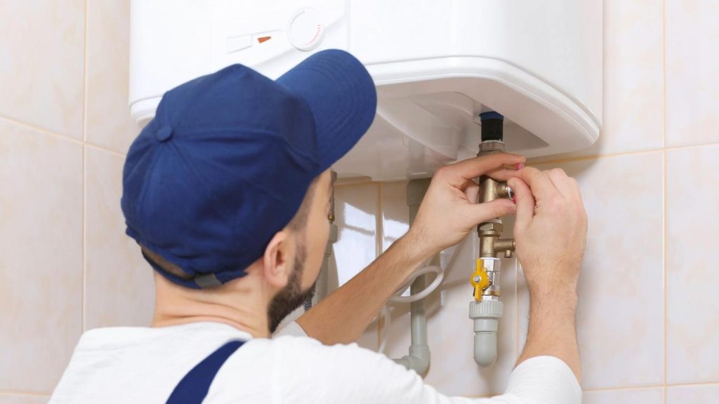 Plumber servicing a residential water heater connection